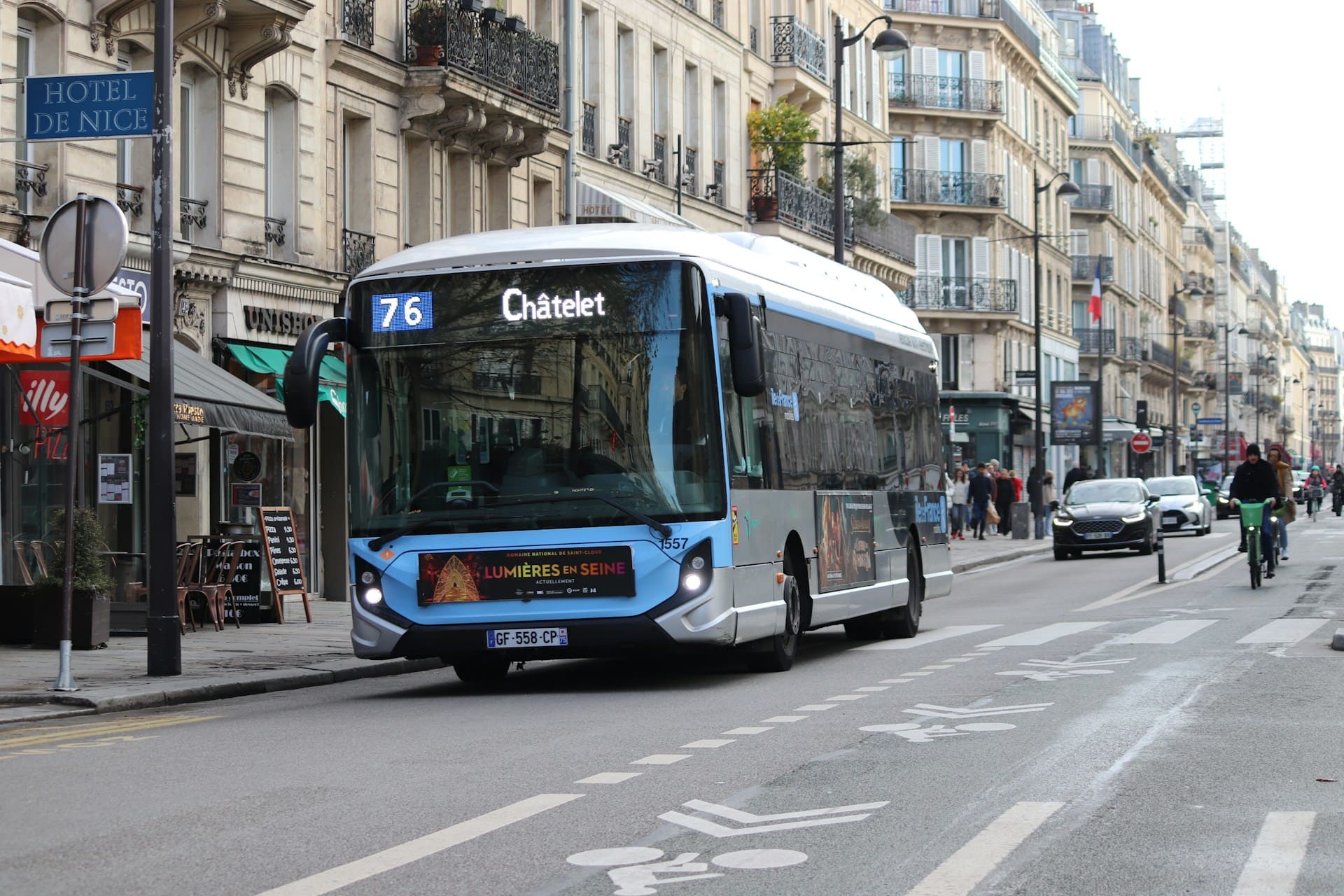 City bus running in the city center alongside bicycles, illustrating intermodality and the combined use of public transportation and active mobility.